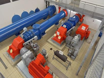 Die zwei Maschinensätze im Krafthaus: Durchströmturbine (blau) mit Generator (rot), dazwischen das Getriebe (grau).
